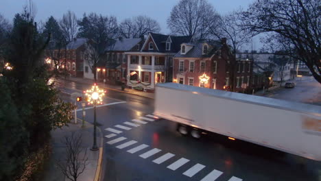 Christmas-decorated-streets-of-small-American-town-in-Pennsylvania-with-semi-trailer-truck-driving-past-the-viewer
