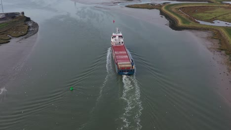 Amplia-Toma-Aérea-Revelada-Del-Barco-Pico-Bergen-Navegando-A-Lo-Largo-Del-Estuario-De-Swale-Hacia-El-Cruce-De-Sheppey-En-Kent,-Reino-Unido