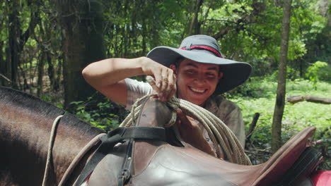 Zeitlupe-Eines-Jungen-Einheimischen-Cowboys-Mit-Großem-Hut,-Der-Das-Seil-Zum-Reiten-In-Nosara,-Costa-Rica,-Bindet