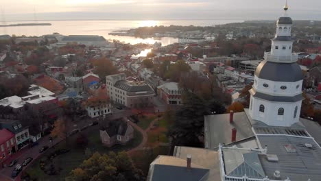 Eine-Drohne-Nimmt-Aufnahmen-Des-Historischen-Maryland-Statehouse-Auf,-Während-Sie-Bei-Sonnenaufgang-In-Richtung-Chesepeake-Bay-Fliegt