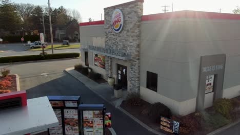 Aerial-rising-shot-of-Burger-King-drive-through-and-restaurant-entrance-on-bright-sunny-day