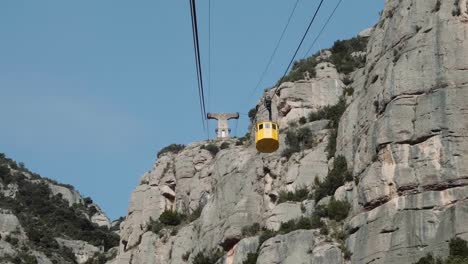 Langsam-Die-Felswand-Von-Montserrat-Hinauf-Bis-Zur-Spitze,-Während-Sie-An-Einer-Gelben-Gondel-Vorbeifahren