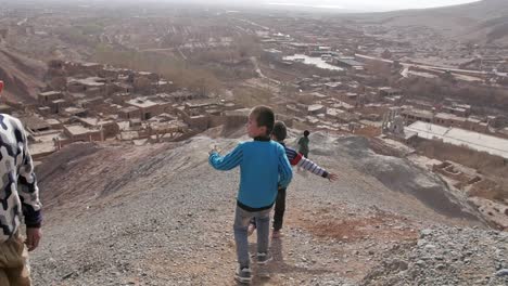 Uigurische-Kinder-Spielen-In-Der-Trockenen,-Sandigen-Landschaft-Im-Dorf-Tuyuk,-China,-Xinjiang---Zeitlupe