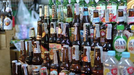 Panning-shot-over-beverage-shelf-display-on-night-food-market,-Bangkok