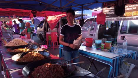Wide-Angle-shot-of-street-vendor-selling-food-to-paying-customer-at-food-market