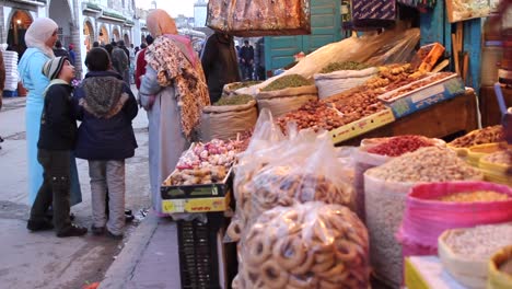 Street-view-of-local-men-and-women-shopping-in-Essaouira,-Morocco-during-the-daytime