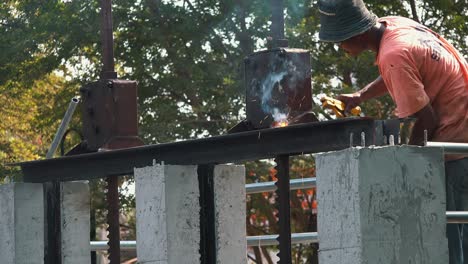 Mittlere-Aufnahme-Eines-Arbeiters,-Der-Auf-Einer-Baustelle-Eine-Metallstange-Schweißt