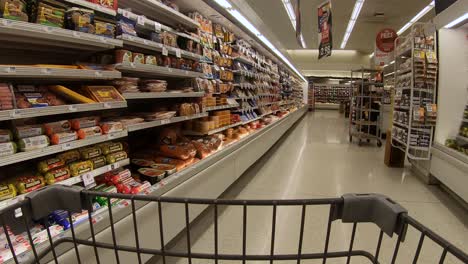 Pov-Aus-Dem-Einkaufswagen-Beim-Gang-Durch-Einen-Gekühlten-Supermarkt-Mit-Speck,-Wurst,-Aufschnitt-Und-Käse