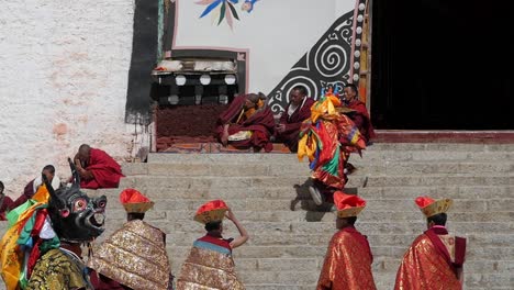 Bunte-Tibetische-Mönchstänzerin,-Die-Die-Klosterstufen-In-Einer-Traditionellen-Rituellen-Cham-tanzzeremonie-Hinaufläuft