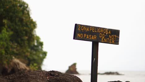 Señal-Bilingüe-De-No-Entrar-En-Las-Rocas-De-La-Playa