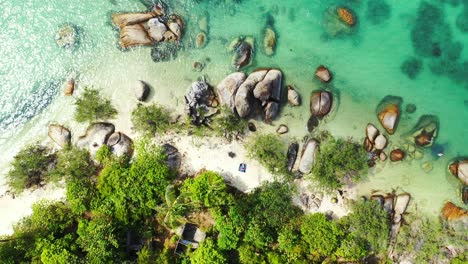Beautiful-unspoiled-nature,-Sandy-beach-surrounded-by-boulders-in-the-azure-tropical-sea