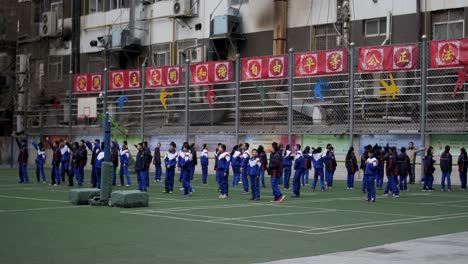 Verschiedene-Junge-Chinesische-Studenten,-Die-Auf-Dem-College-sportplatz-Trainieren-Und-Trainingsanzuguniformen-Tragen