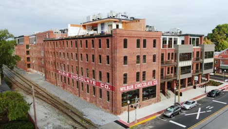 Cinematic-aerial-rising-dolly-shot,-Wilbur-Chocolate-Factory-converted-to-hotel-and-condos,-under-construction