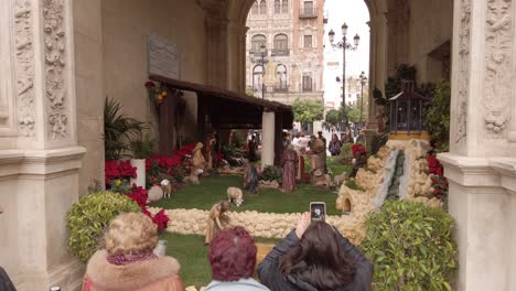 Gente-Española-Mira-La-Escena-De-La-Natividad-Fuera-De-La-Iglesia-En-Sevilla,-España,-Cámara-Lenta