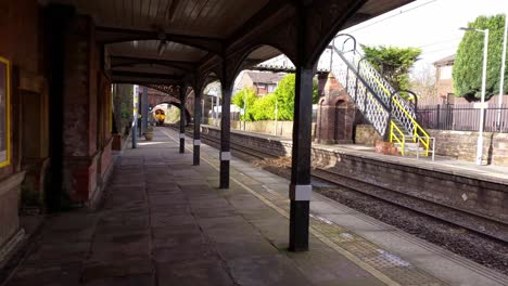 Trains-passing-both-ways-on-station-platform-travelling-on-railway-track