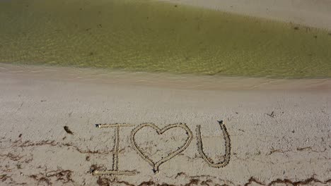 I-love-U-written-in-the-sand-as-water-laps-onto-the-beach