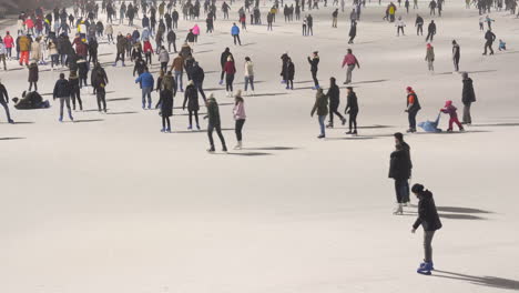 Schlittschuhlaufende-Leute,-Die-Im-Winter-Auf-Weißem-Eis-Schlittschuh-Laufen