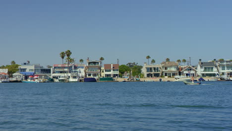 Slow-motion-Boat-on-the-Water-Passing-by-Luxury-Homes