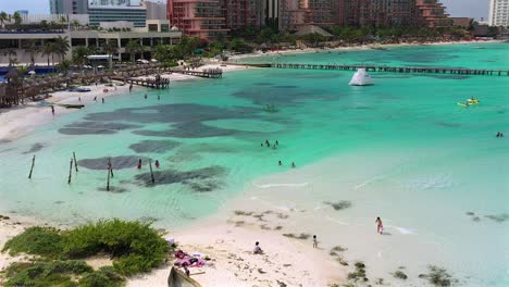 Imágenes-Aéreas-De-Drones-De-Personas-Disfrutando-De-Su-Día-En-El-Océano-Azul-Claro,-Nadando-Y-Haciendo-Kayak,-En-La-Playa,-Detrás-Del-Hyatt-Ziva-En-Cancún,-México