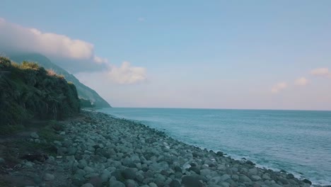 Filmisches-Luftvideo-Von-Wellen,-Die-An-Einem-Späten-Nachmittag-Am-Valugan-Boulder-Beach-In-Batanes,-Philippinen,-Zu-Einem-Großen-Steinhaufen-Spritzen