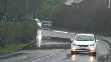 Los-Vehículos-Que-Circulan-A-Lo-Largo-De-La-Curva-De-La-Esquina-De-La-Carretera-Inundada-Flash-Tormentoso-Lluvioso-Uk