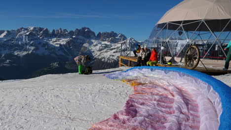 Dosel-De-Parapente-Preparado-En-El-Suelo-Con-Un-Grupo-Preparándose-Para-Volar-En-Trentino,-Italia