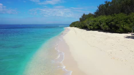 Beautiful-paradise-beach-with-bright-blue-waters-and-white-sand-with-lush-green-flora
