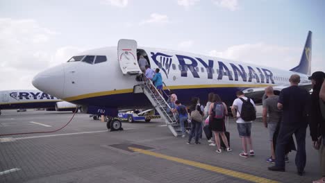 Cola-De-Personas-Que-Abordan-El-Avión-De-Ryanair-Antes-Del-Despegue,-Vista-Panorámica-Lateral