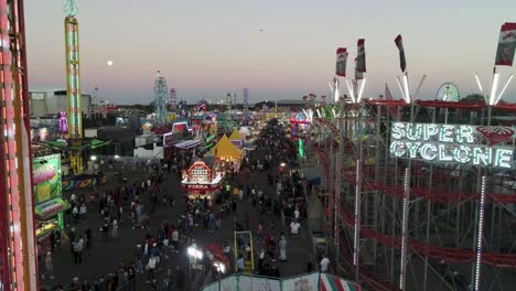 Luftaufnahme-Der-Florida-State-Fair-Während-Des-Sonnenuntergangs-Mit-Achterbahn-Und-Herumlaufenden-Menschen