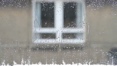 Cerca-De-Aguanieve-Derritiéndose-En-Una-Ventana-Mientras-Llueve-Afuera