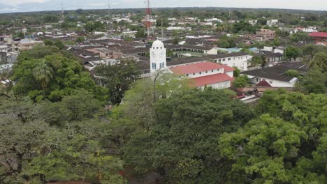 Church-in-the-town-of-San-Martín---Colombia,-with-vegetation-close-to-the-population,-Catholic-belief,-Aerial-drone-video