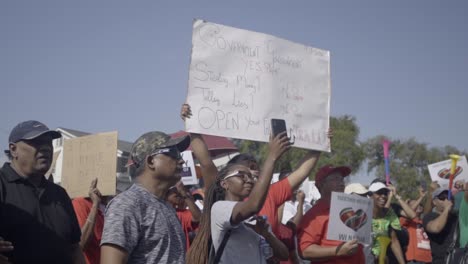 Woman-holding-up-protest-sign-during-protest-in-Suriname,-slow-motion