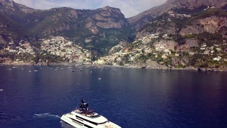 Amalfiküste-Mit-Superyacht,-Die-In-Der-Nähe-Auf-Dem-Tiefblauen-Wasser-Des-Mittelmeers-Verankert-Ist,-Luftüberführungsaufnahme