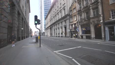 Eine-Einzelne-Person-Geht-Allein-Auf-Der-Belebten-Bishopsgate-Street-Im-Zentrum-Von-London-Spazieren,-Die-Jetzt-Aufgrund-Der-Sperrung-Des-Coronavirus-Leer-Und-Ruhig-Ist