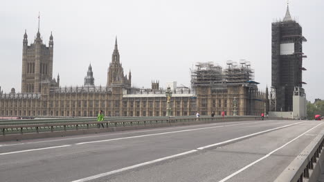 Ein-Zeitraffer-Von-Fahrzeugen-Und-Menschen,-Die-Während-Des-Ausbruchs-Des-Coronavirus-Eine-Fast-Menschenleere-Brücke-Von-Westminster-überqueren,-Vorbei-An-Der-Brücke-Der-Houses-Of-Parliament