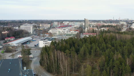 Aerial,-tracking,-drone-shot-of-buildings-in-a-small-town,-cloudy,-spring-day,-in-Viikki,-Finland