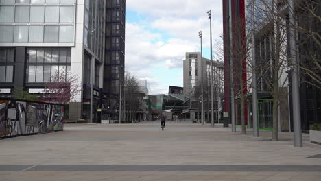 Un-Grupo-De-Personas-Va-En-Bicicleta-Hacia-Un-Centro-Comercial-Casi-Desierto-De-Westfield-En-Stratford,-En-El-Este-De-Londres,-En-Lo-Que-Normalmente-Es-Un-Ajetreado-Día-De-Compras-Durante-El-Brote-De-Coronavirus