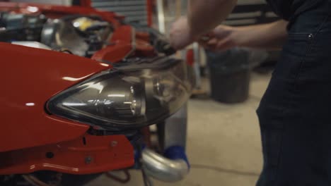 Plano-Cerrado-De-Un-Hombre-Instalando-Un-Faro-En-Un-Nissan-Silvia-Rojo