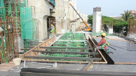 Bauarbeiter-Installieren---Fertigen-Holzschalungen-Und-Bewehrungsstäbe-Auf-Der-Baustelle