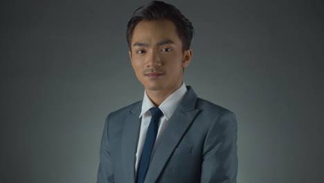 Young-Asian-businessman-wearing-a-grey-suit---portrait-of-success