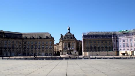 Place-De-La-Bourse-Mit-Fahrrädern,-Die-Aufgrund-Der-Covid-19-pandemie-An-Einem-Fast-Leeren-Platz-Vorbeifahren,-Stabiler-Handschuss