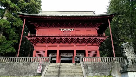 Eine-Japanerin-Geht-Die-Treppe-Zum-Roten-Eingangstor-Des-Iwakiyama-schreins-Hinauf