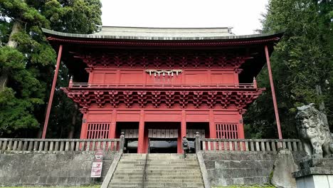 Una-Mujer-Japonesa-Está-Subiendo-Las-Escaleras-Hasta-La-Puerta-De-Entrada-Roja-Del-Santuario-De-Iwakiyama