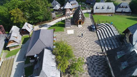 Chapel-with-a-vintage-black-car-on-the-Village-of-Kustendorf-custom-built-for-the-movie-Life-Is-a-Miracle,-Aerial-dolly-out-reveal-shot
