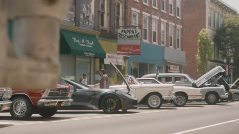 Classic-American-muscle-cars-lined-up-at-auto-show-in-small-town-Pennsylvania,-Slide-Left