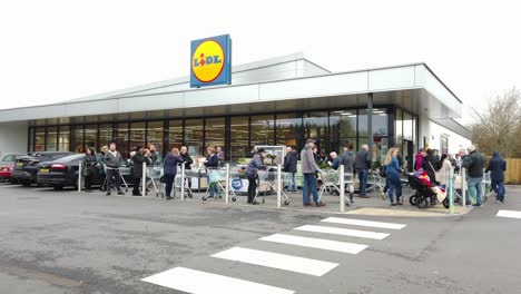 Queues-of-'panic-buyers-outside-supermarket,-Lidl-during-the-Coronavirus-outbreak-in-England,-UK
