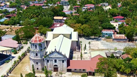 Fascinante-Foto-Orbital-De-La-Antigua-Iglesia-Española-Frente-Al-Mar-De-La-Hermosa-Vista-De-La-Costa,-La-Iglesia-De-Nuestra-Señora-De-La-Inmaculada-Concepción-En-Oslob-Cebu,-Filipinas