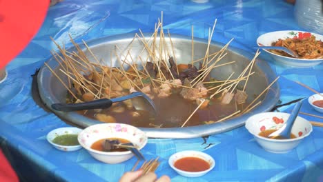 The-Close-up-Footage-of-Myanmar-Styled-Pork-Stick-Hot-Pot,-Popular-Street-Food-in-Sangkhlaburi,-Thailand