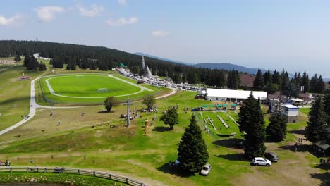 Pequeño-Lago-En-El-Hotel-Deportivo-Con-Pista-De-Bombas-Para-Bicicletas-Y-Campo-De-Fútbol-Al-Lado-De-La-Iglesia,-Tiro-Aéreo