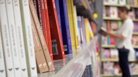 Mujer-Borrosa-En-Una-Librería-Revisando-Libros